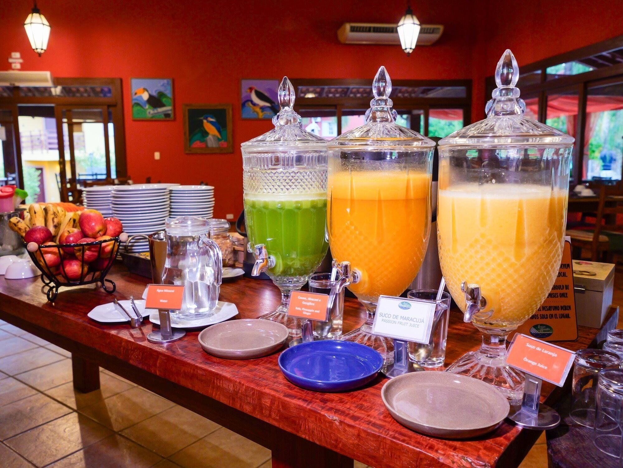 A buffet with various fruit juices and a fruit basket.