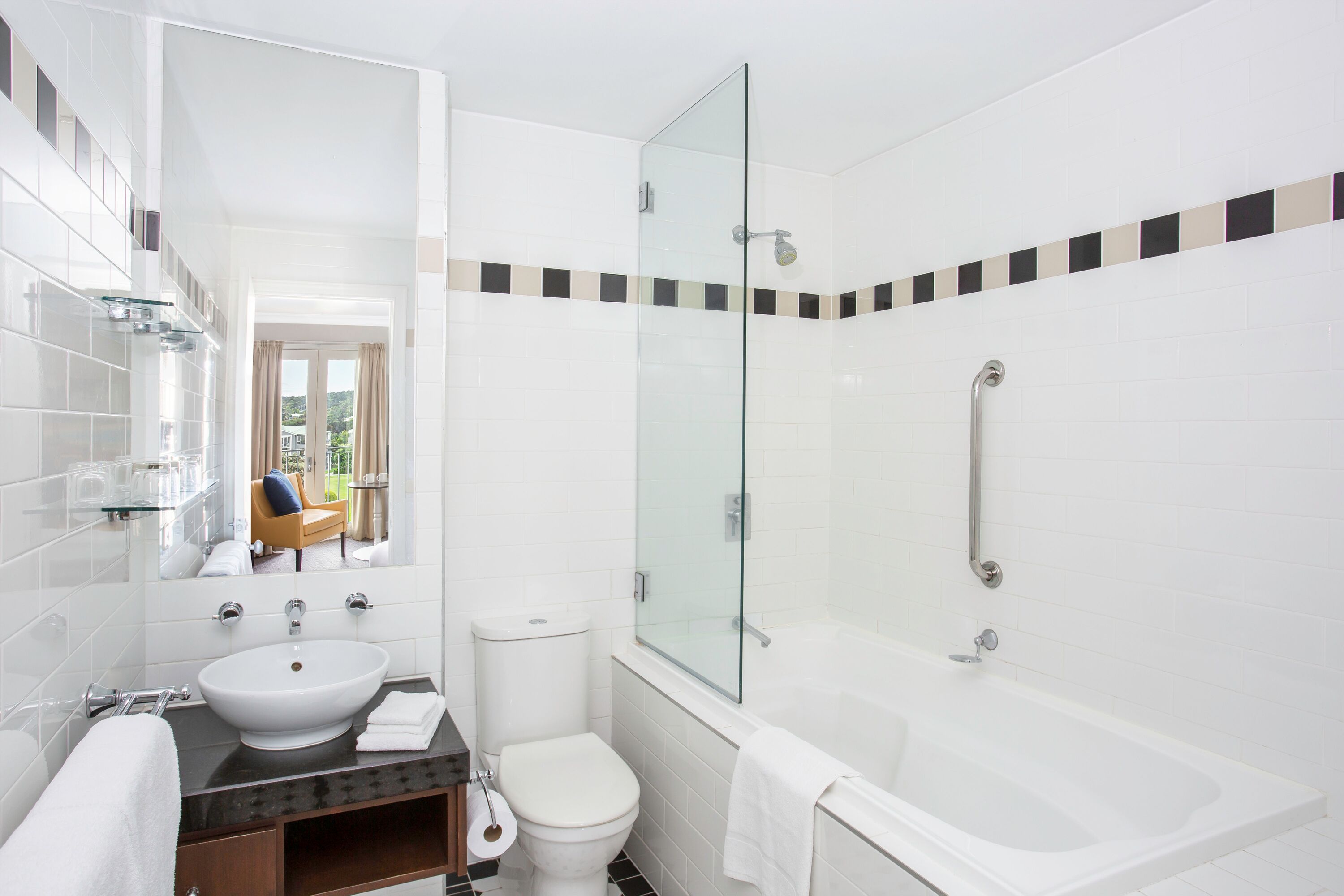 A modern bathroom with a glass-enclosed shower, a white sink, and a toilet.