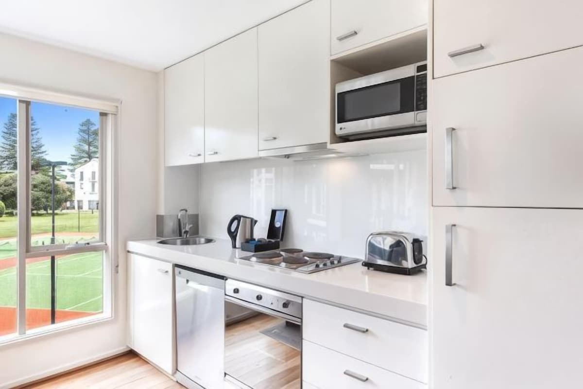Una cucina moderna con mobili bianchi, un forno a microonde ed una lavastoviglie.