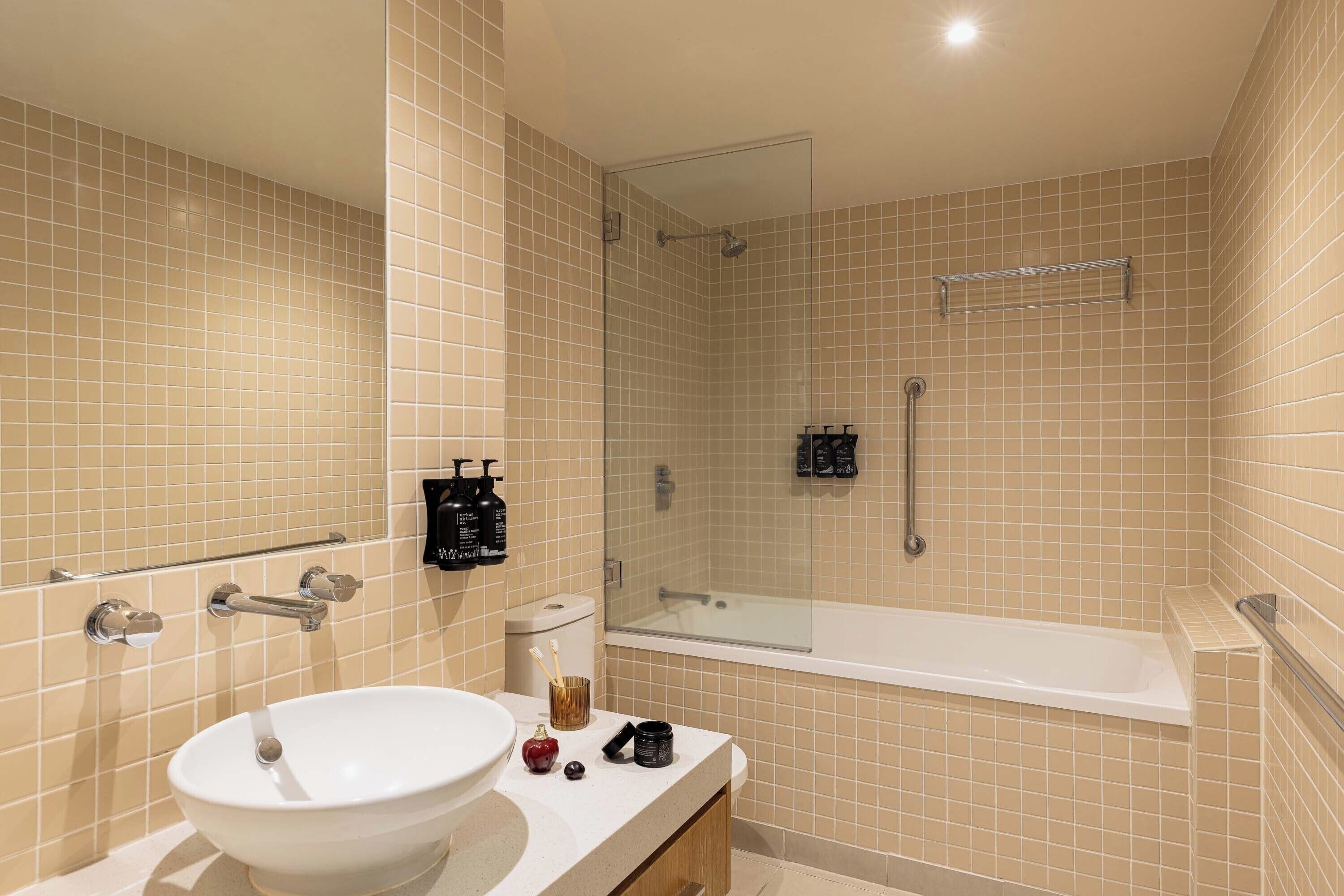 A bathroom with a white sink, a glass shower enclosure, and a bathtub.