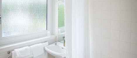 A bathroom with a toilet, sink, and bathtub.