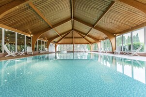 Una piscina techada, sillones reclinables de piscina