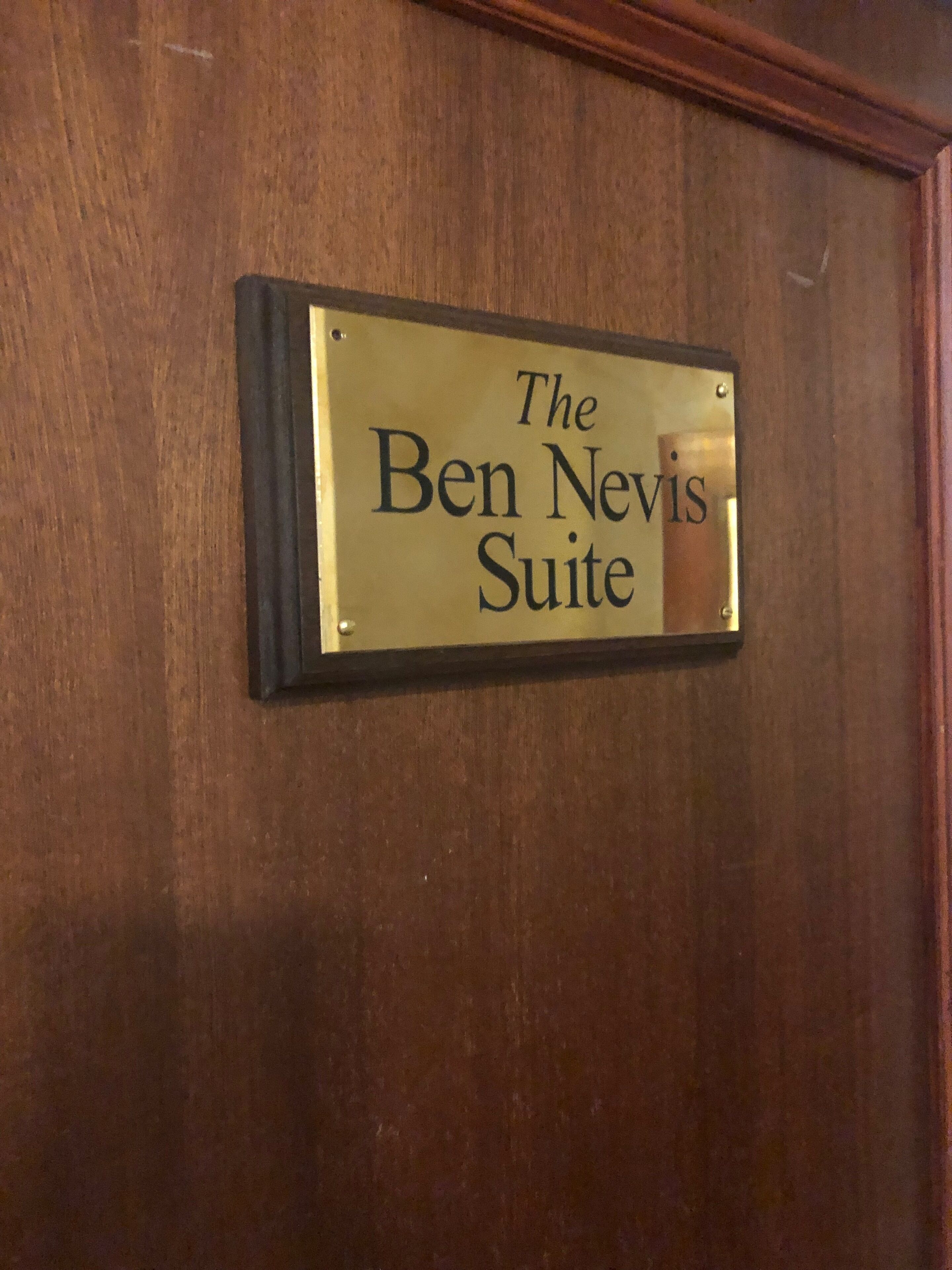 A brass plaque on a wooden door with the text "The Ben Nevis Suite".