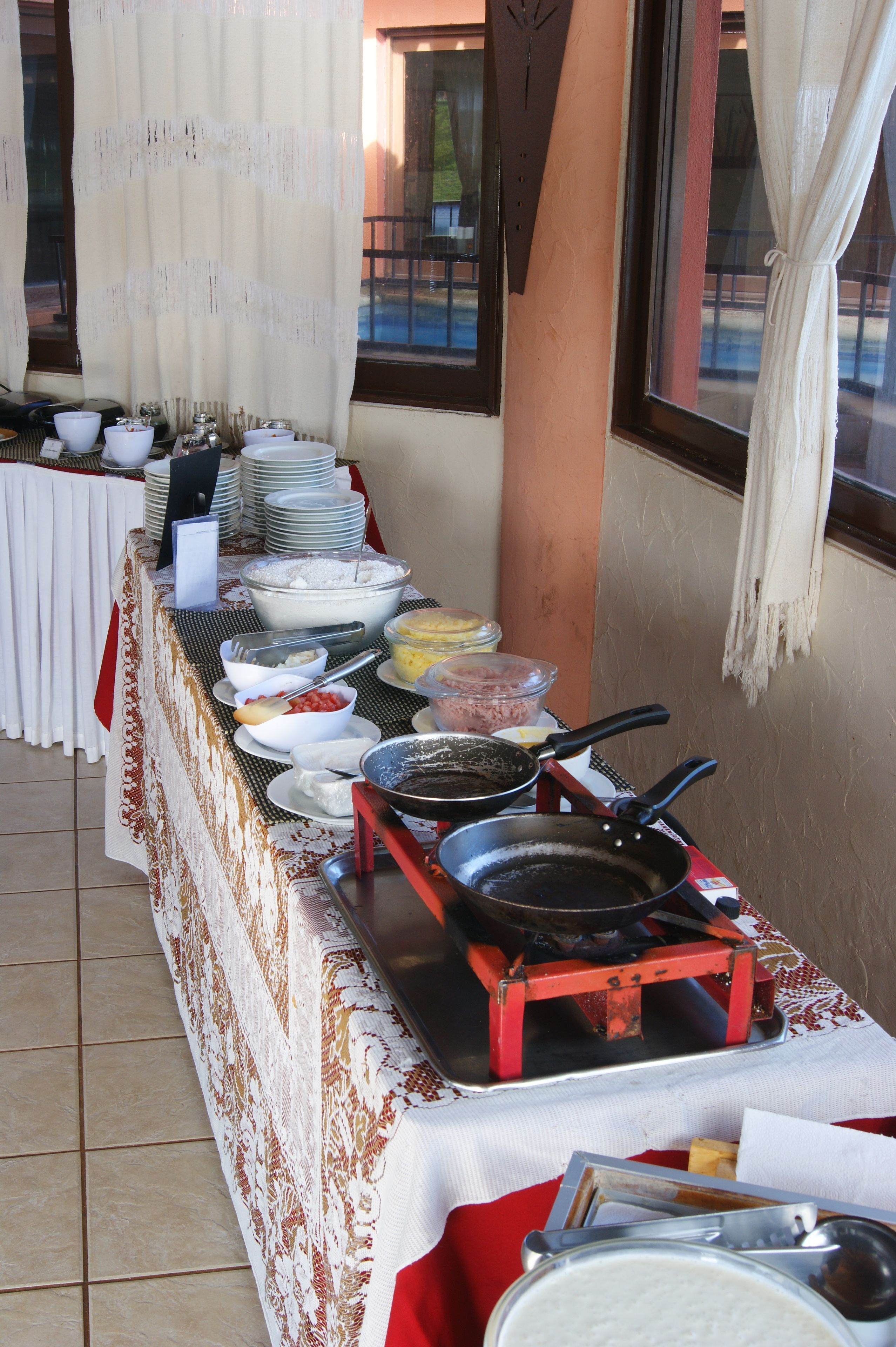 A buffet table with various food items and utensils.