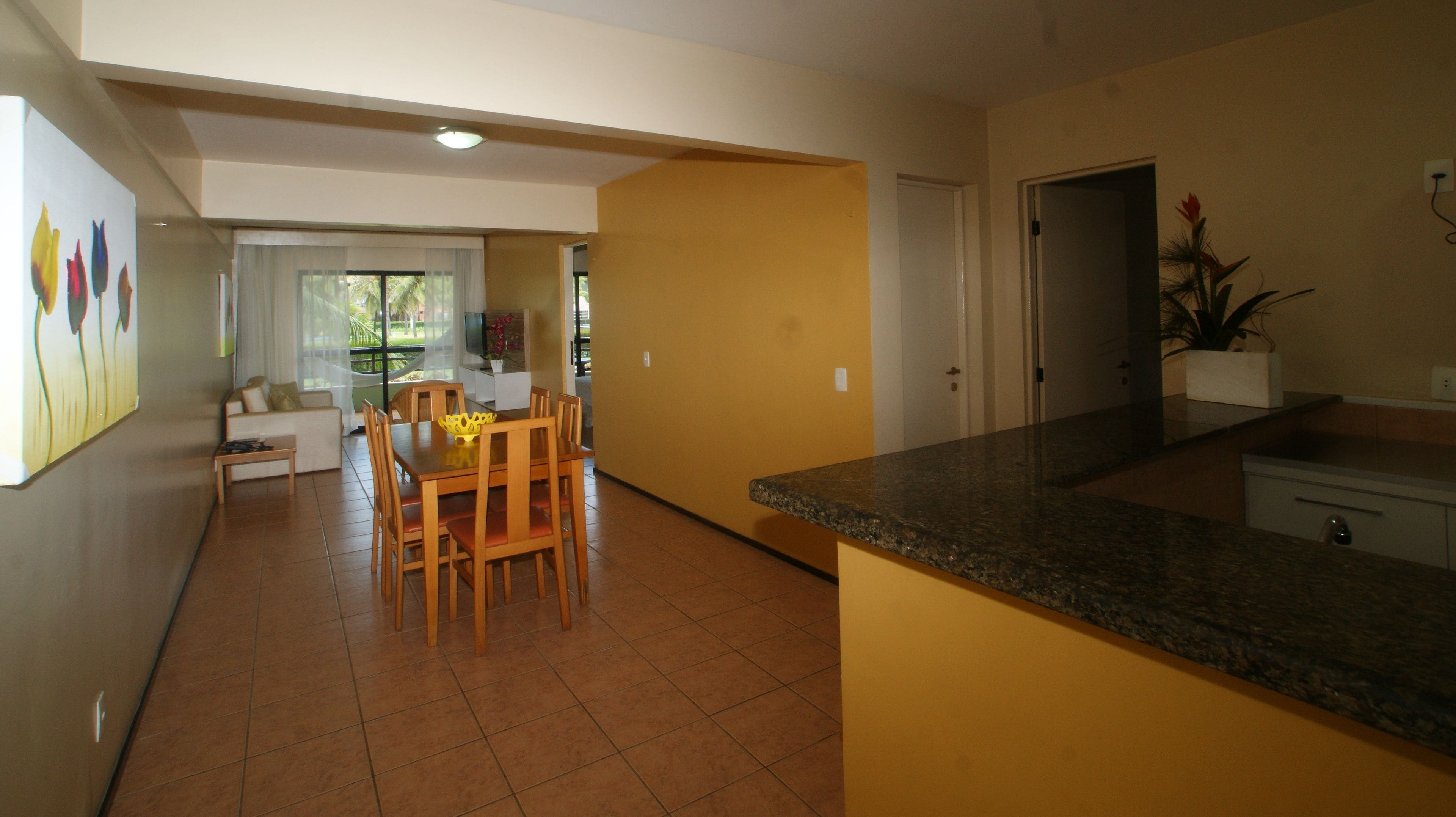 Un amplio espacio de sala con una mesa de comedor y sillas, un sofá y un televisor.