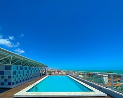 Una piscina al aire libre, sillones reclinables de piscina