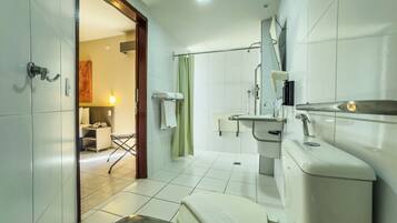 A modern bathroom with a toilet, bidet, and shower area.