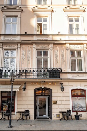 A building with a sign reading 'HOTEL SENACKI,' featuring a classic architectural style with ornate window frames and a balcony with wrought iron railings. - Hotel Senacki (Kraków)