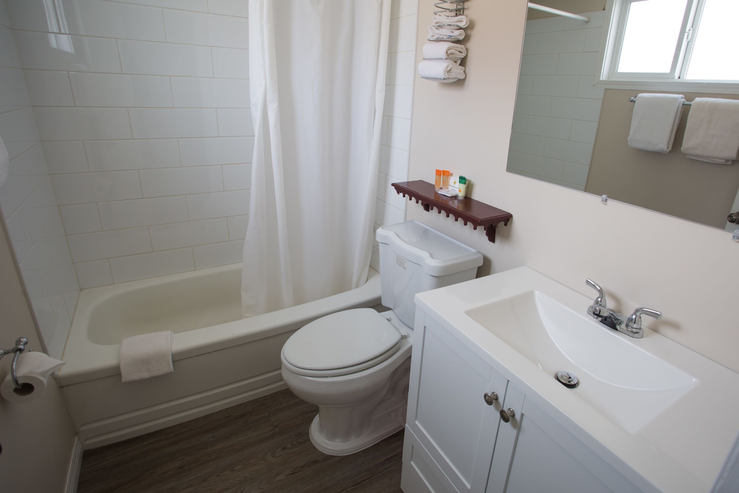 A bathroom with a bathtub, toilet, and sink.