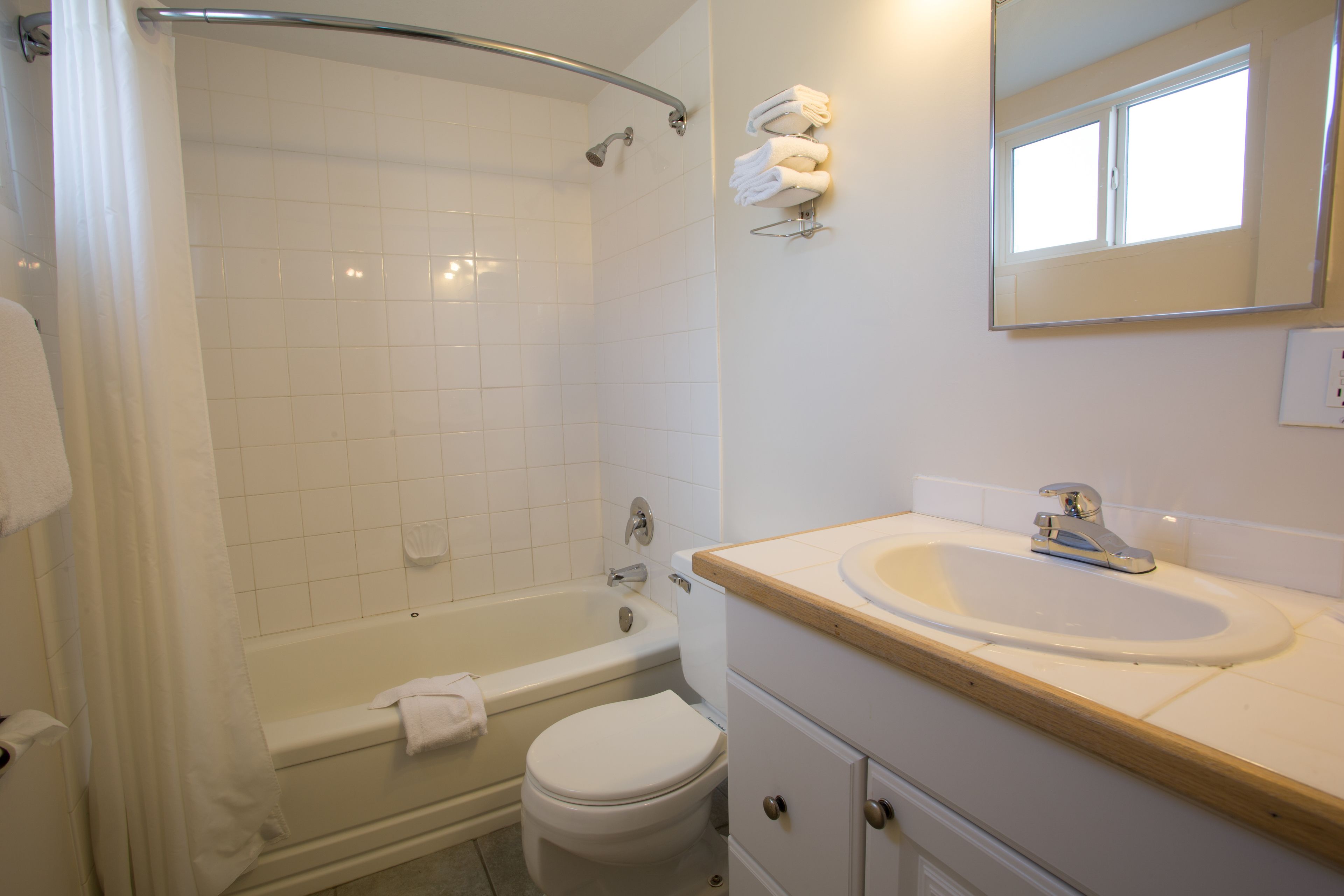 A bathroom with a bathtub, toilet, and sink.