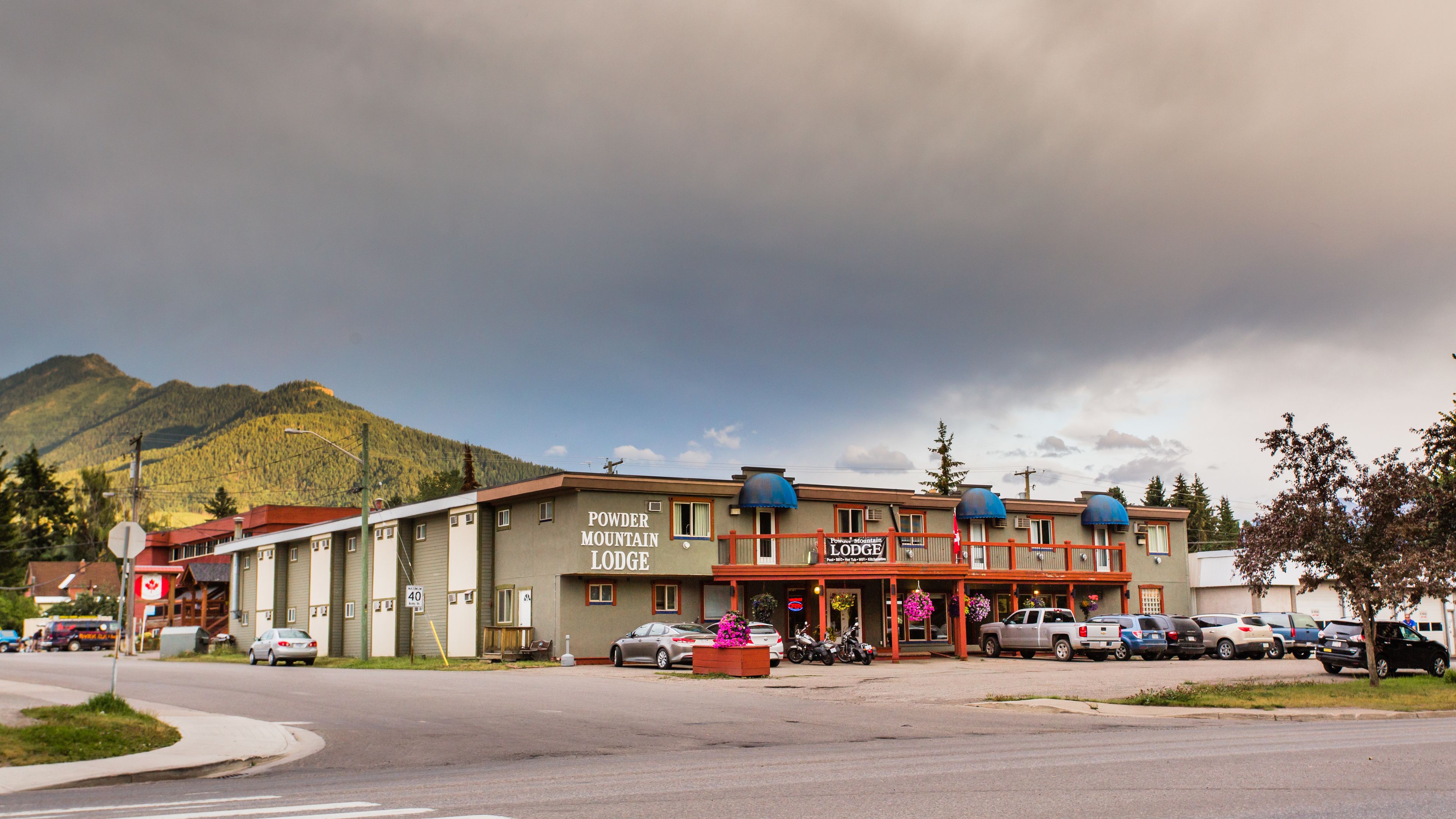 Un motel con un cartello che recita 'Powder Mountain Lodge' e un segnale stradale che indica un limite di velocità di 40 miglia.