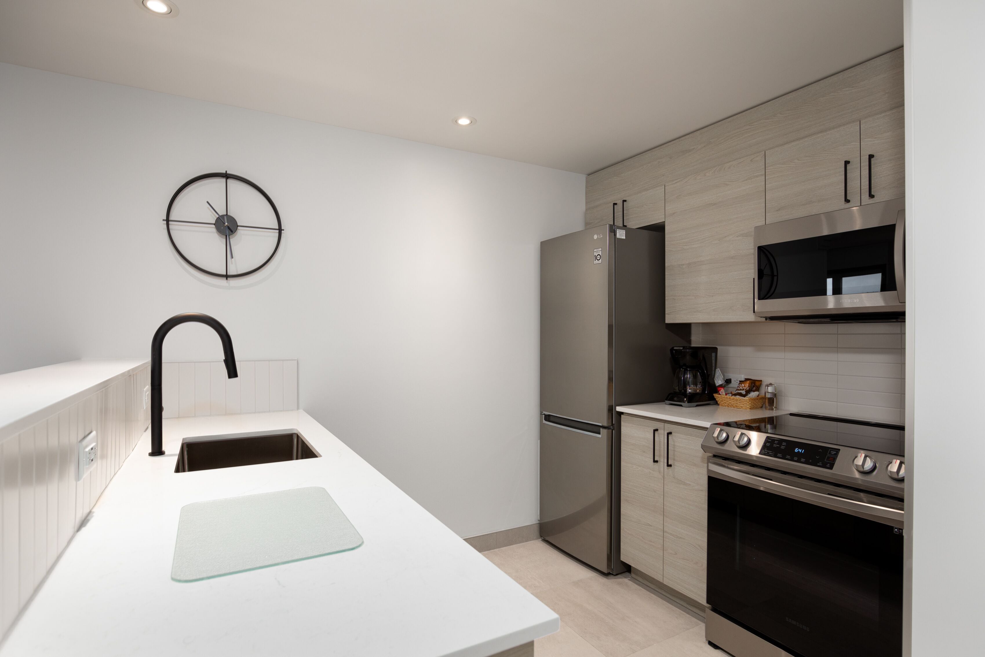Una cocina moderna con un refrigerador de acero inoxidable, un microondas, una estufa y un fregadero.