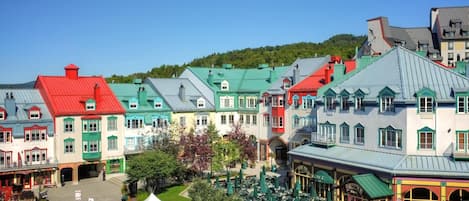 Un conjunto de edificios coloridos con estilos arquitectónicos diferentes, un patio central y zonas de estar al aire libre.