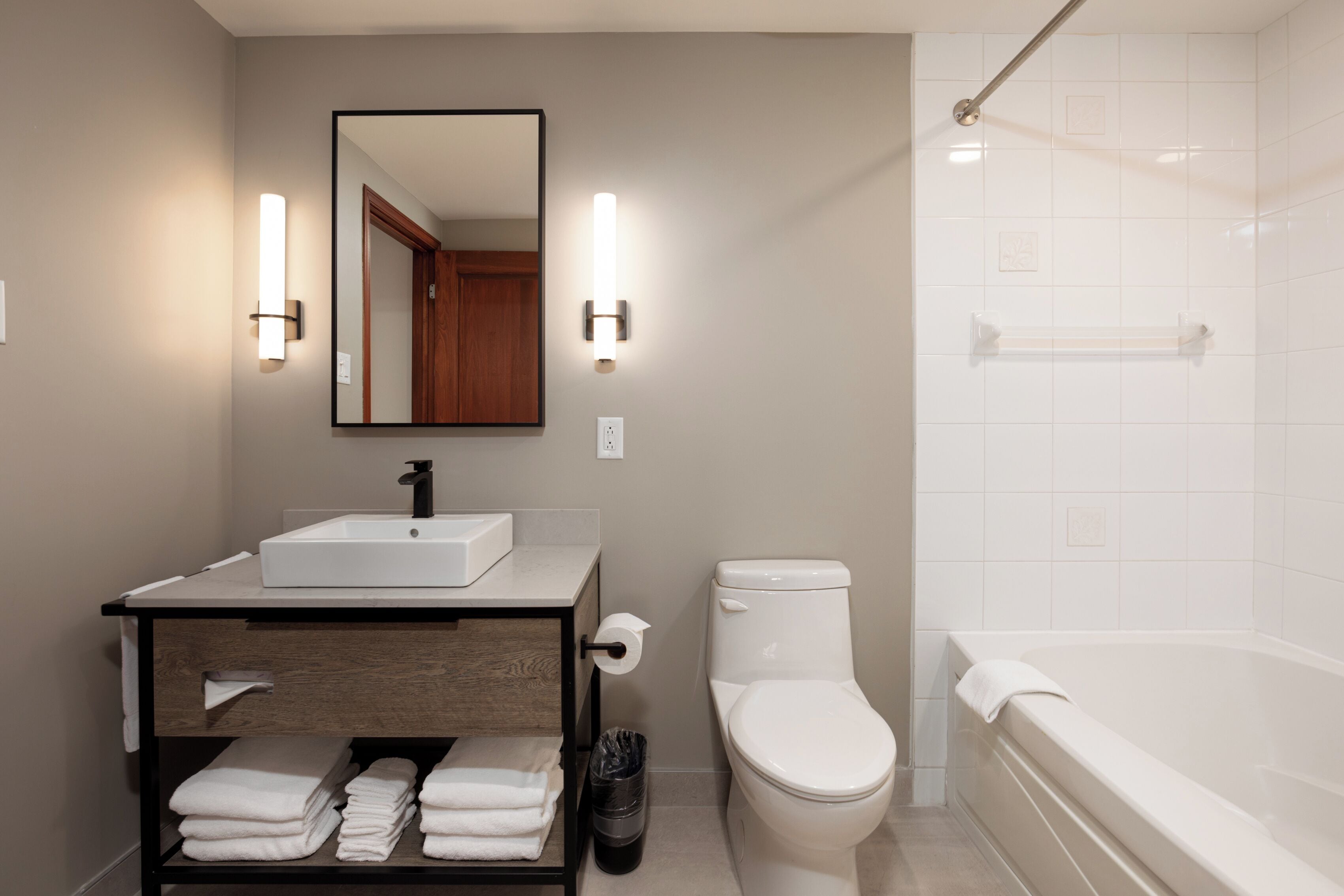 A modern bathroom with a sink, toilet, and bathtub.