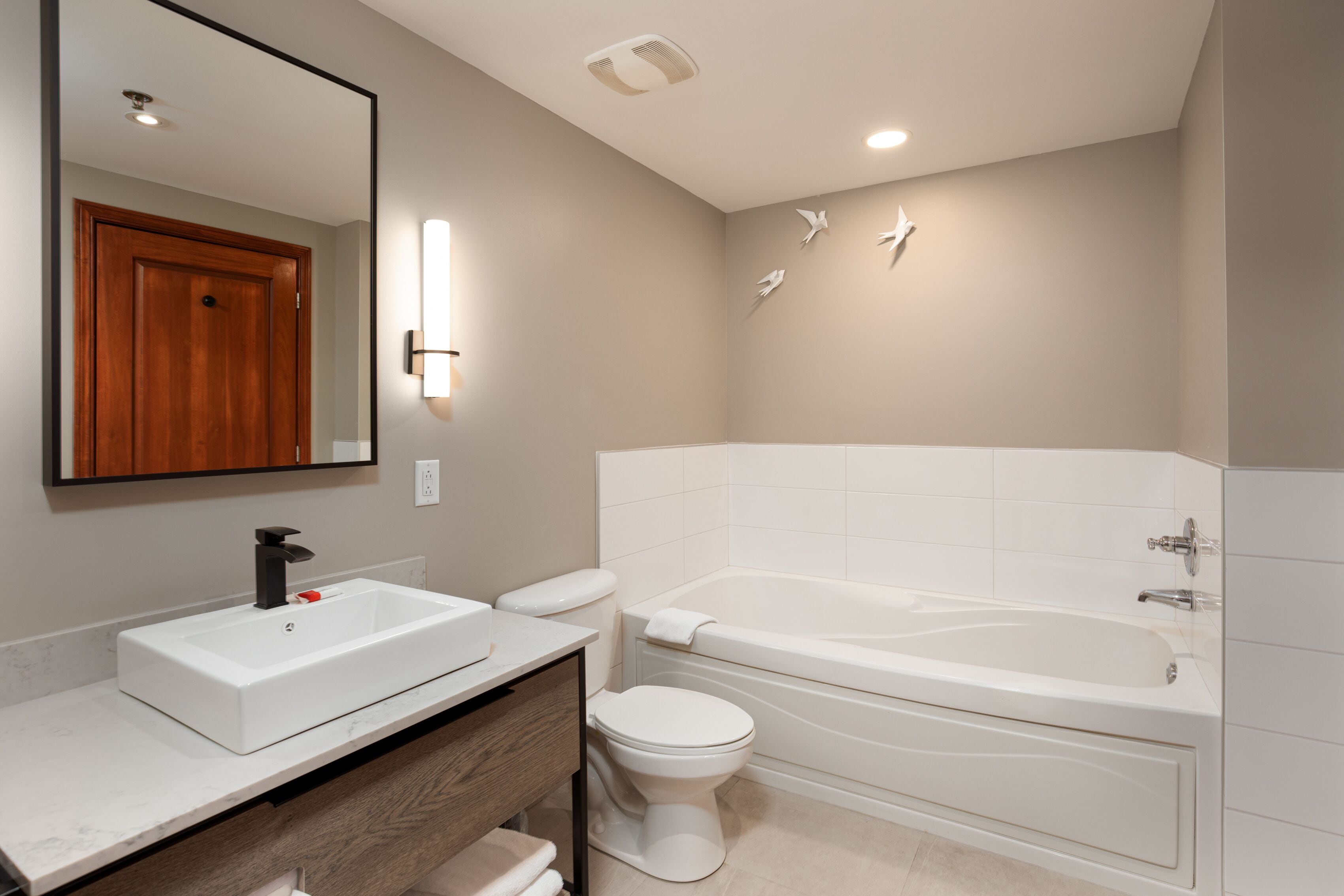 Une salle de bain moderne avec un lavabo, des toilettes et une baignoire, le tout de couleur blanche.