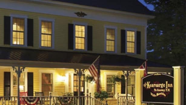 A two-story building with a porch, an American flag, and a sign for Kearnsge Inn. - Kearsarge Inn (North Conway)