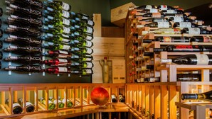 Une cave à vin contenant de nombreuses bouteilles de vin, disposées sur des étagères et des murs en bois.