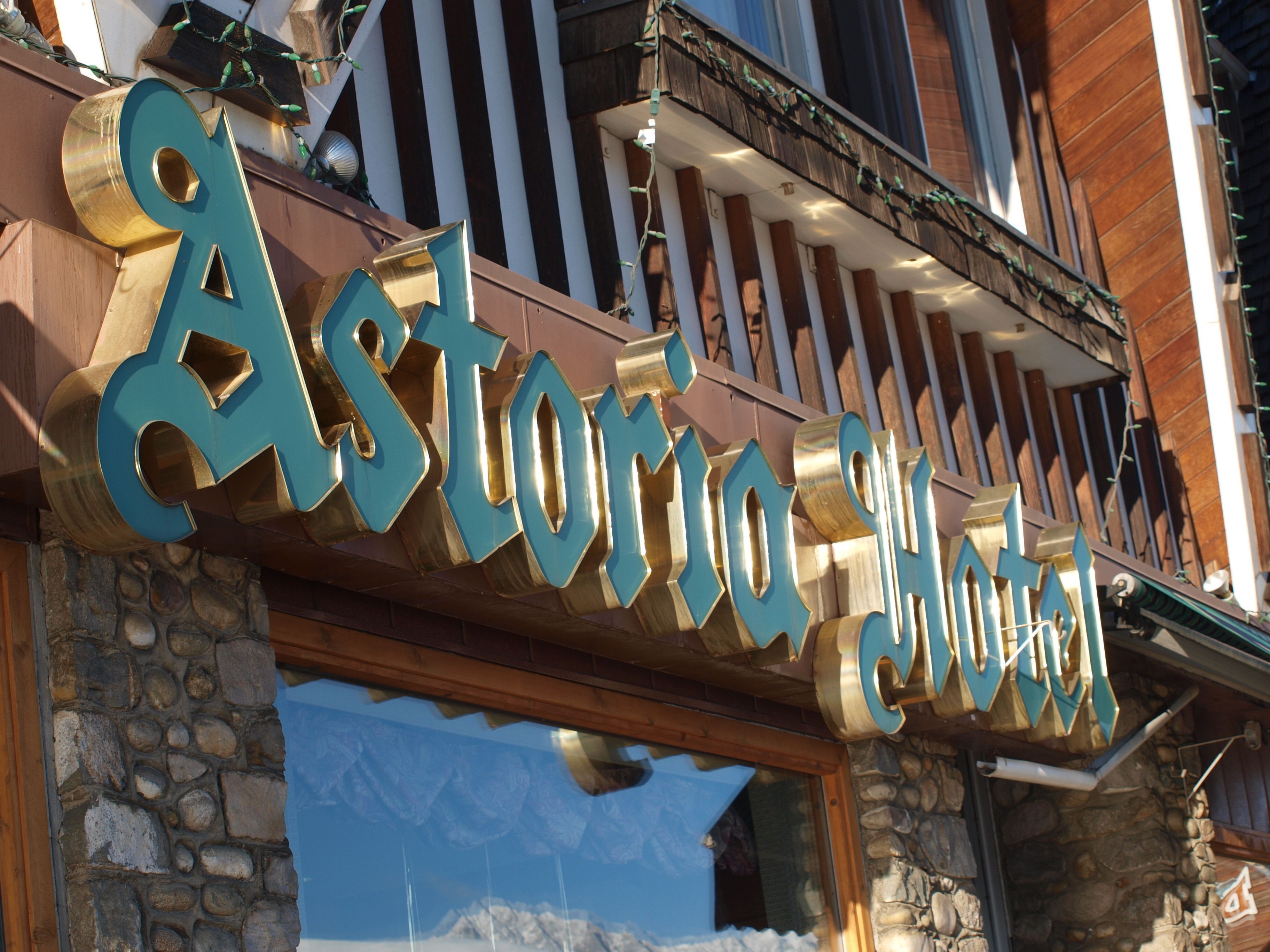A hotel sign with the name "Astoria Hotel" in large, metallic letters.