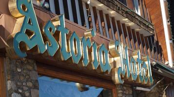 A hotel sign with the name "Astoria Hotel" in large, metallic letters.