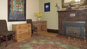 A traditional living room with a fireplace, a large framed painting, and a decorative rug. - Downtown Bed and Breakfast (Ottawa)