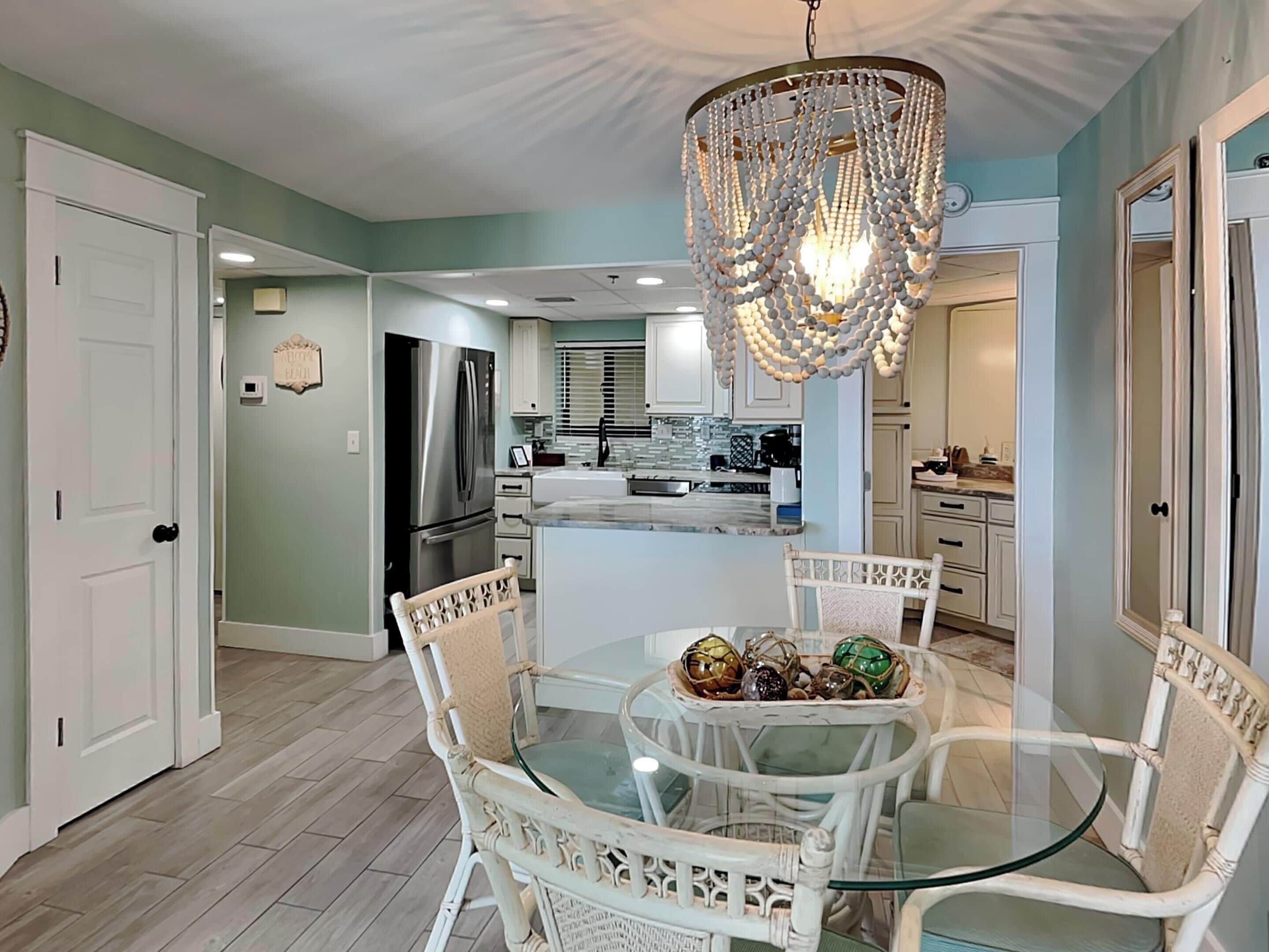 A modern kitchen with white cabinetry, a central island, and a chandelier.