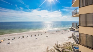 A beach view from a balcony with a clear sky and sun shining. - Sunbird Beach Resort by Resort Collection (Panama City Beach)