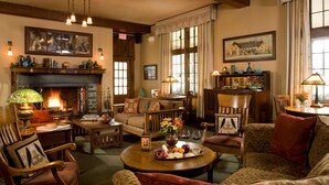 A cozy living room with a fireplace, comfortable seating, and a dining area.