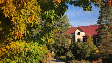 A house with a red roof, surrounded by trees and a garden.