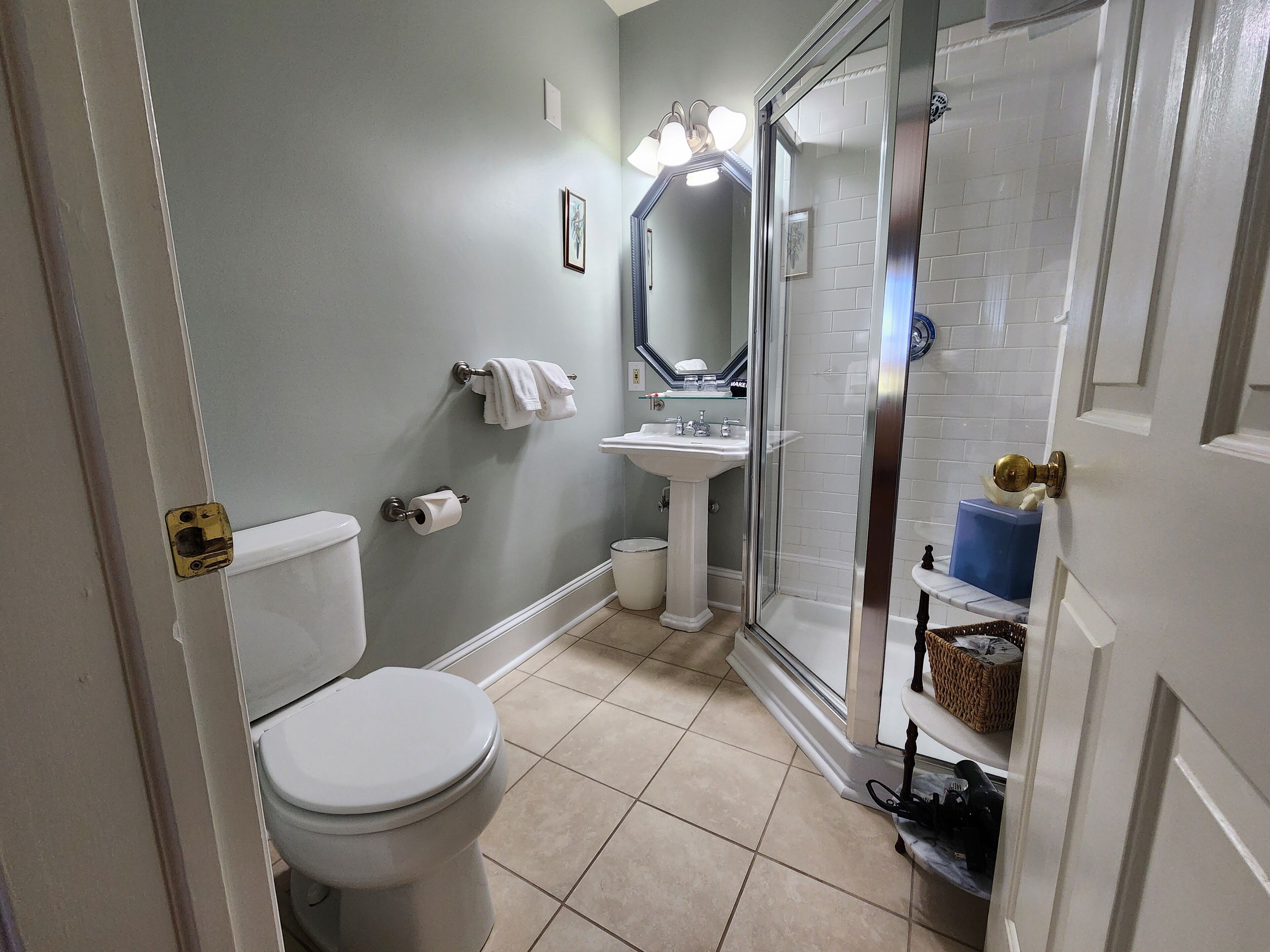 A bathroom with a toilet, sink, and shower area.