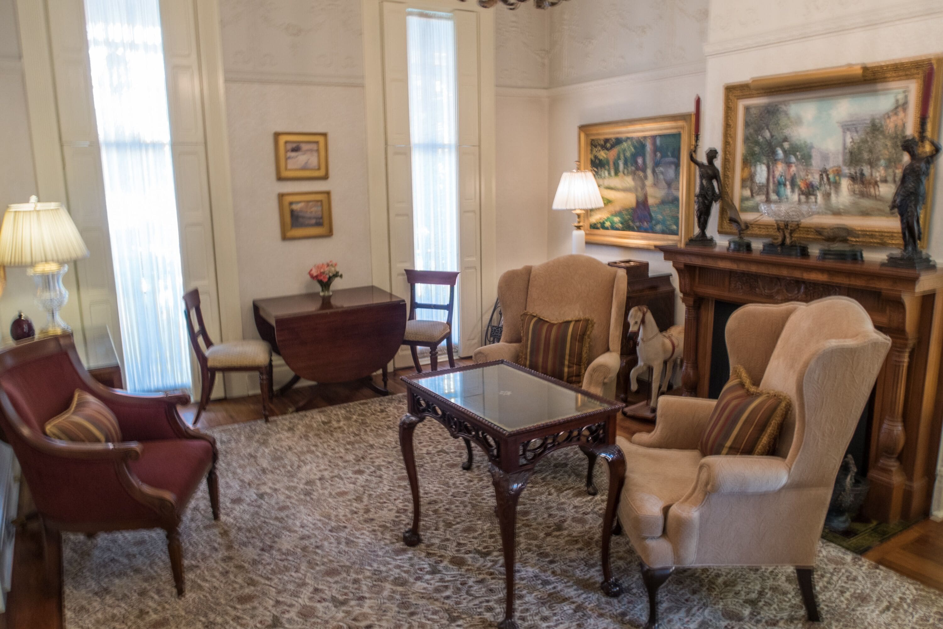 A traditional room with a fireplace, a wooden coffee table, and classic furniture including armchairs and a sofa.
