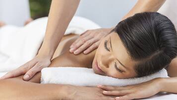 A person receiving a massage on a white towel.