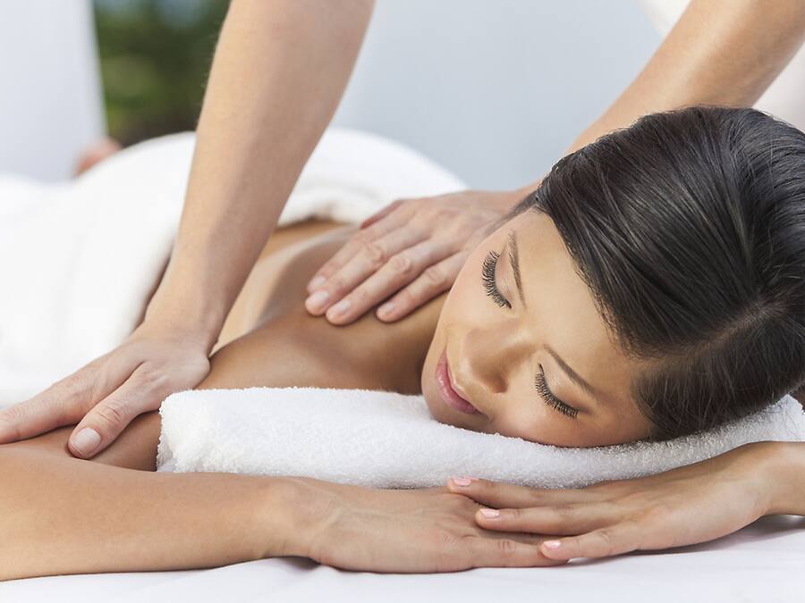 A person receiving a massage on a white towel.