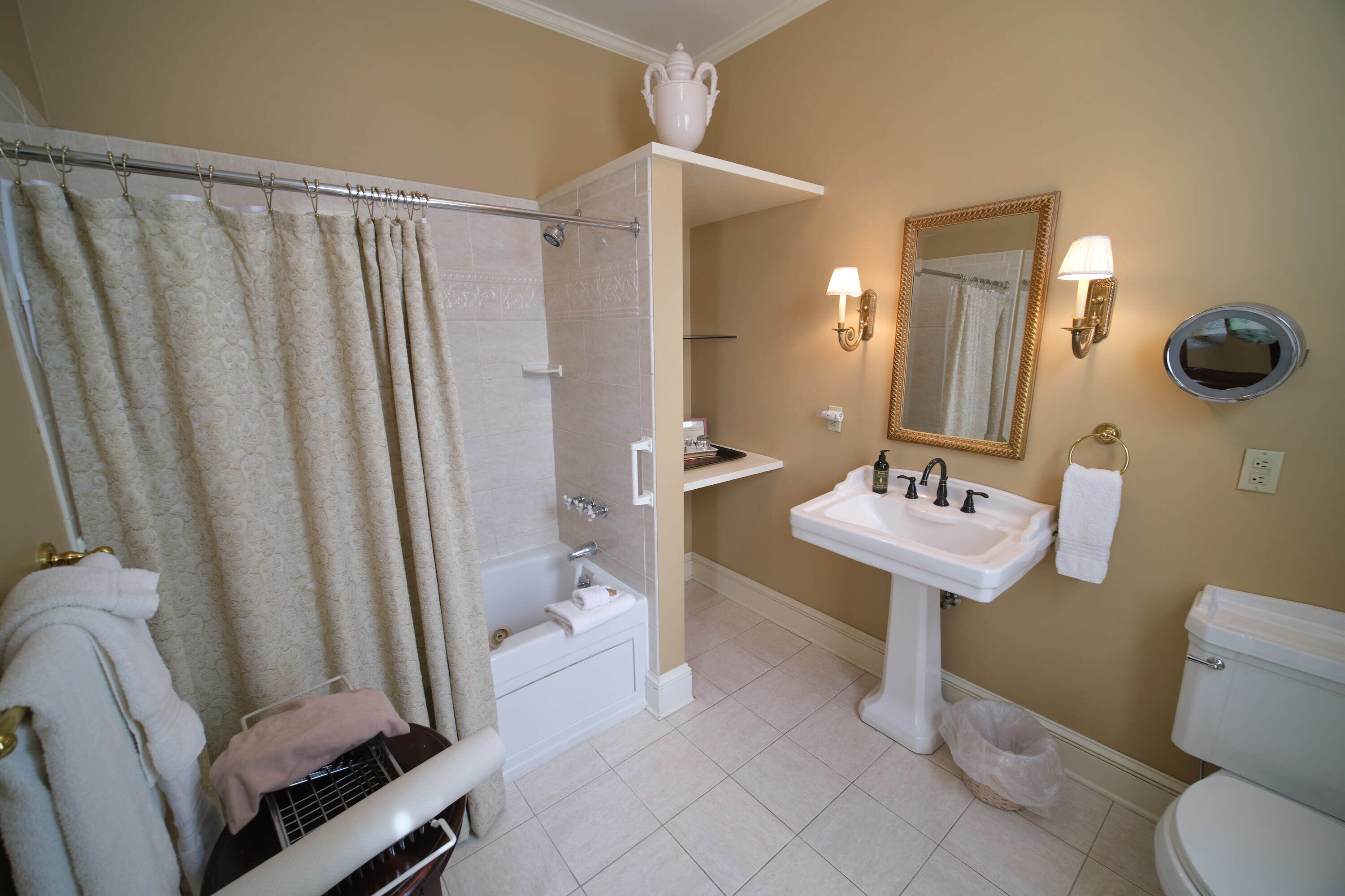 A bathroom with a bathtub, shower, sink, and toilet.