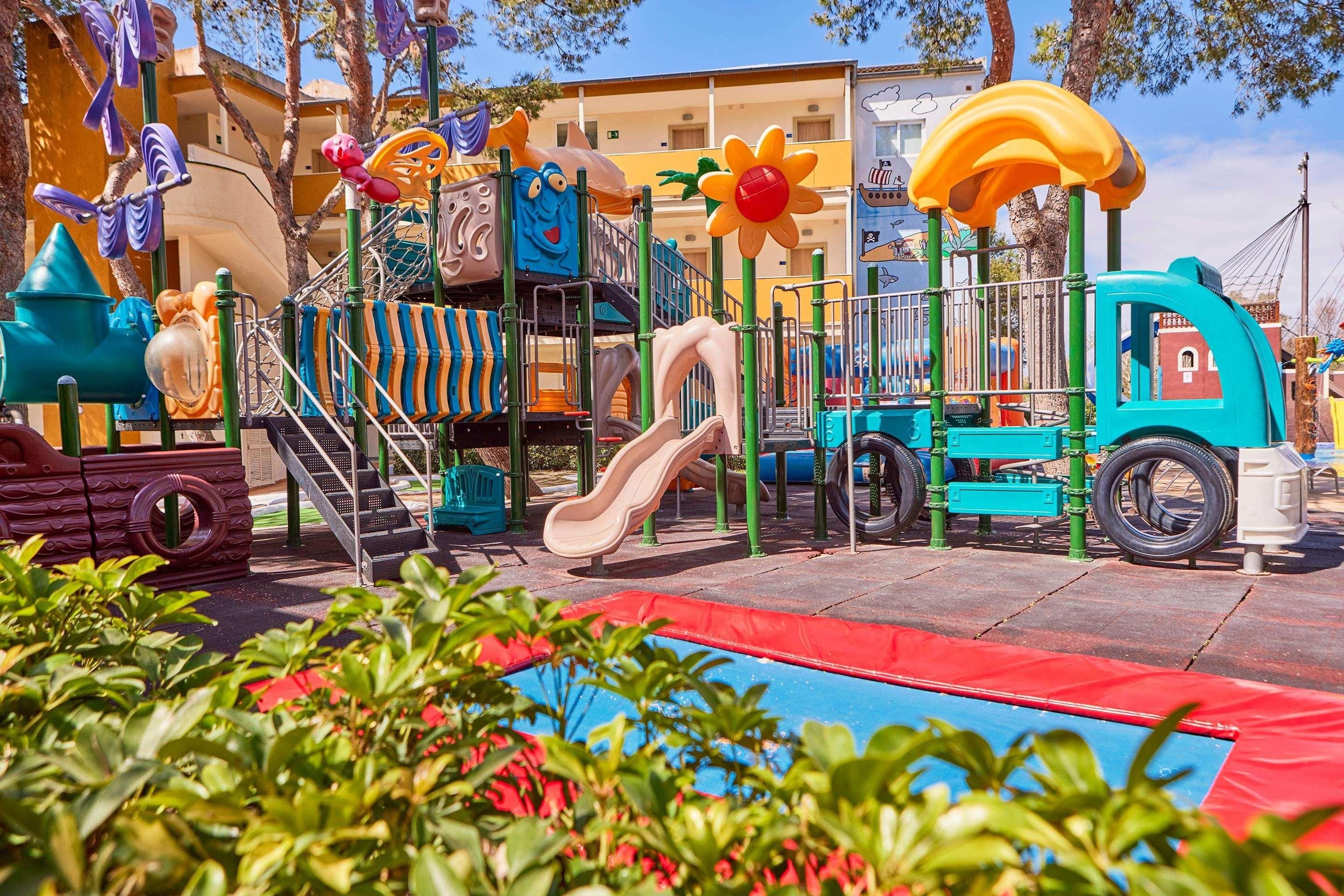 A playground with slides, climbing structures, and a tire play area.