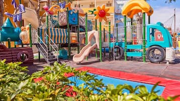 A playground with slides, climbing structures, and a tire play area.