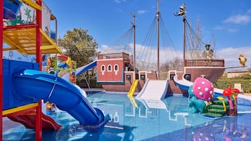 Un parque acuático con toboganes, un barco pirata y una estructura de juegos.