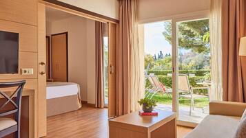 Une chambre moderne avec un lit, un bureau et une vue sur un jardin.