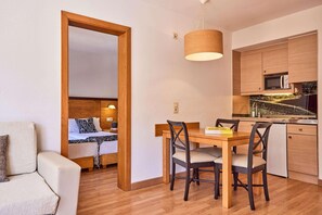 A compact living space with a kitchenette, a dining area, and a bedroom. - Zafiro Tropic (Alcúdia)