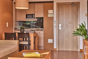 Una cocina moderna con microondas, estufa y comedor con sillas y mesa.