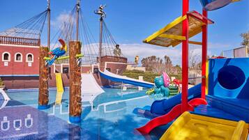 Parque acuático con toboganes, un barco pirata y una estructura de juegos.