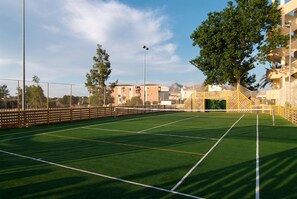 A sports court with a net, surrounded by a fence and trees. - Zafiro Tropic (Alcúdia)