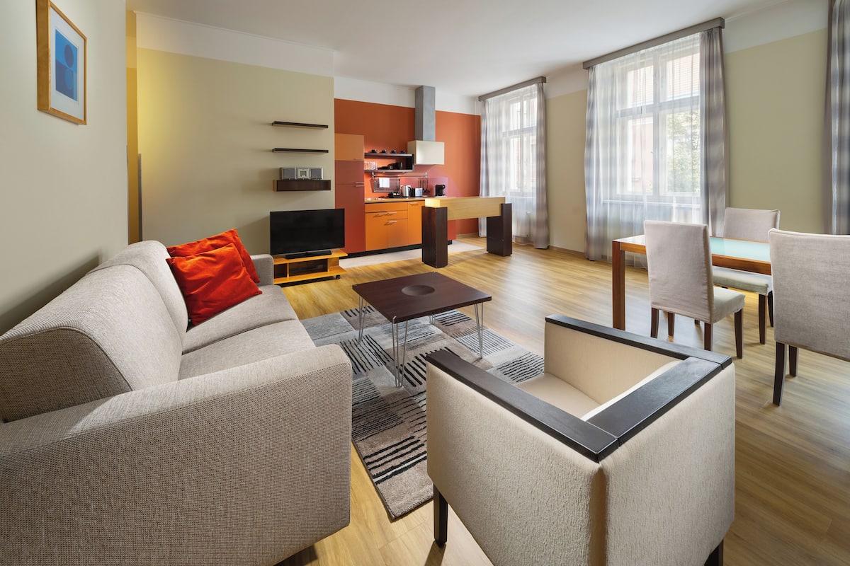 Una sala de estar moderna con sofá, mesa de centro y comedor.