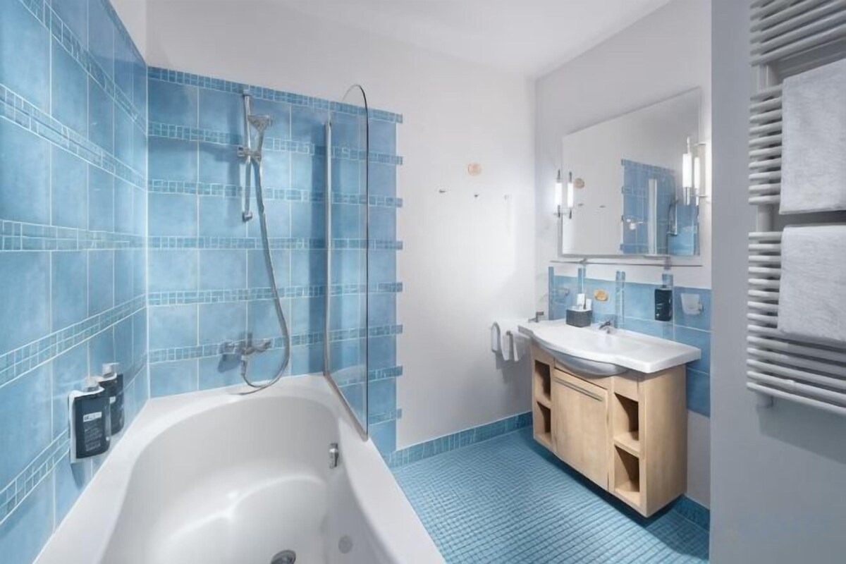Bathtub, designer toiletries, hair dryer, towels