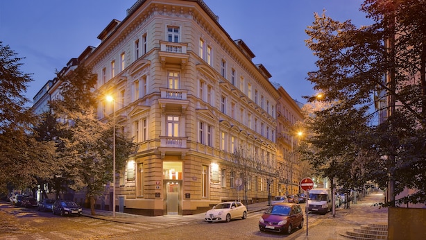 A historic building with a corner entrance, multiple floors, and a balcony on the second floor. - Mamaison Residence Belgicka (Prague)