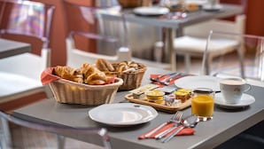 A breakfast setting with croissants, a glass of orange juice, and a cup of coffee on a table. - Mamaison Residence Belgicka (Prague)