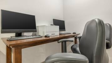A workspace with two monitors, a keyboard, a mouse, and a chair.