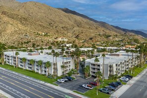 A multi-story hotel with a parking lot, surrounded by palm trees and mountains. - Hilton Vacation Club Palm Canyon Palm Springs (Palm Springs)