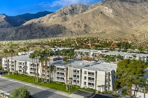 A multi-story hotel with a flat roof, surrounded by palm trees and a desert landscape with mountains in the background. - Hilton Vacation Club Palm Canyon Palm Springs (Palm Springs)
