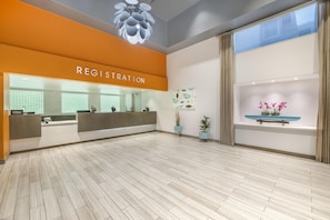 A hotel registration area with a modern design, a reception desk, and a large window with curtains. - Hilton Vacation Club Palm Canyon Palm Springs (Palm Springs)