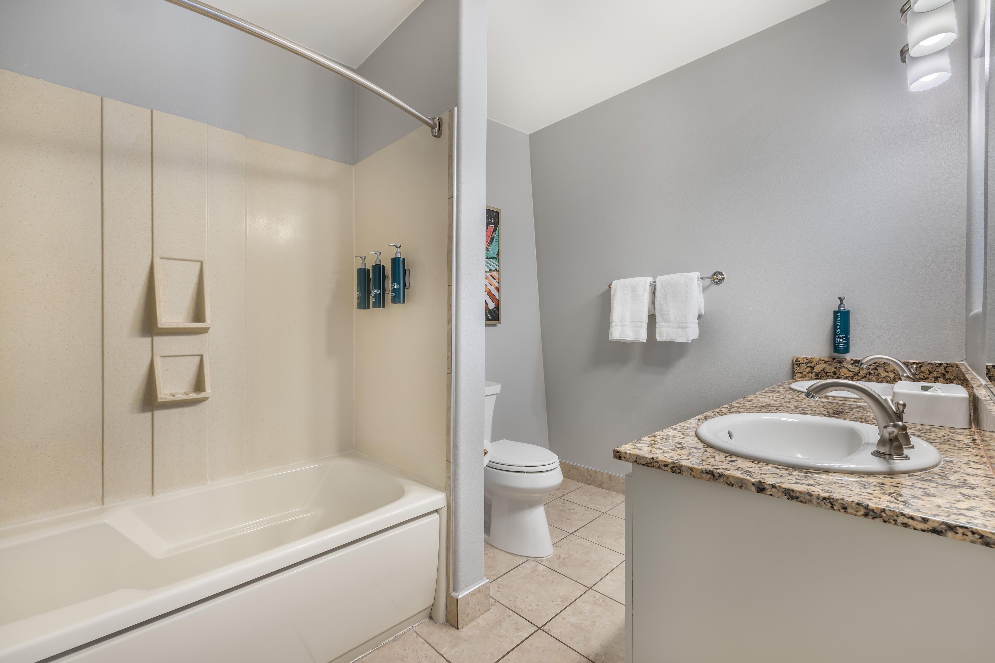 A modern bathroom with a bathtub, toilet, and sink.